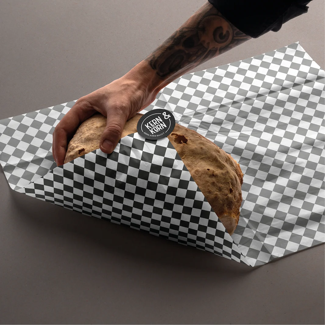 Brot das in kariertes Packpapier eingewickelt wird